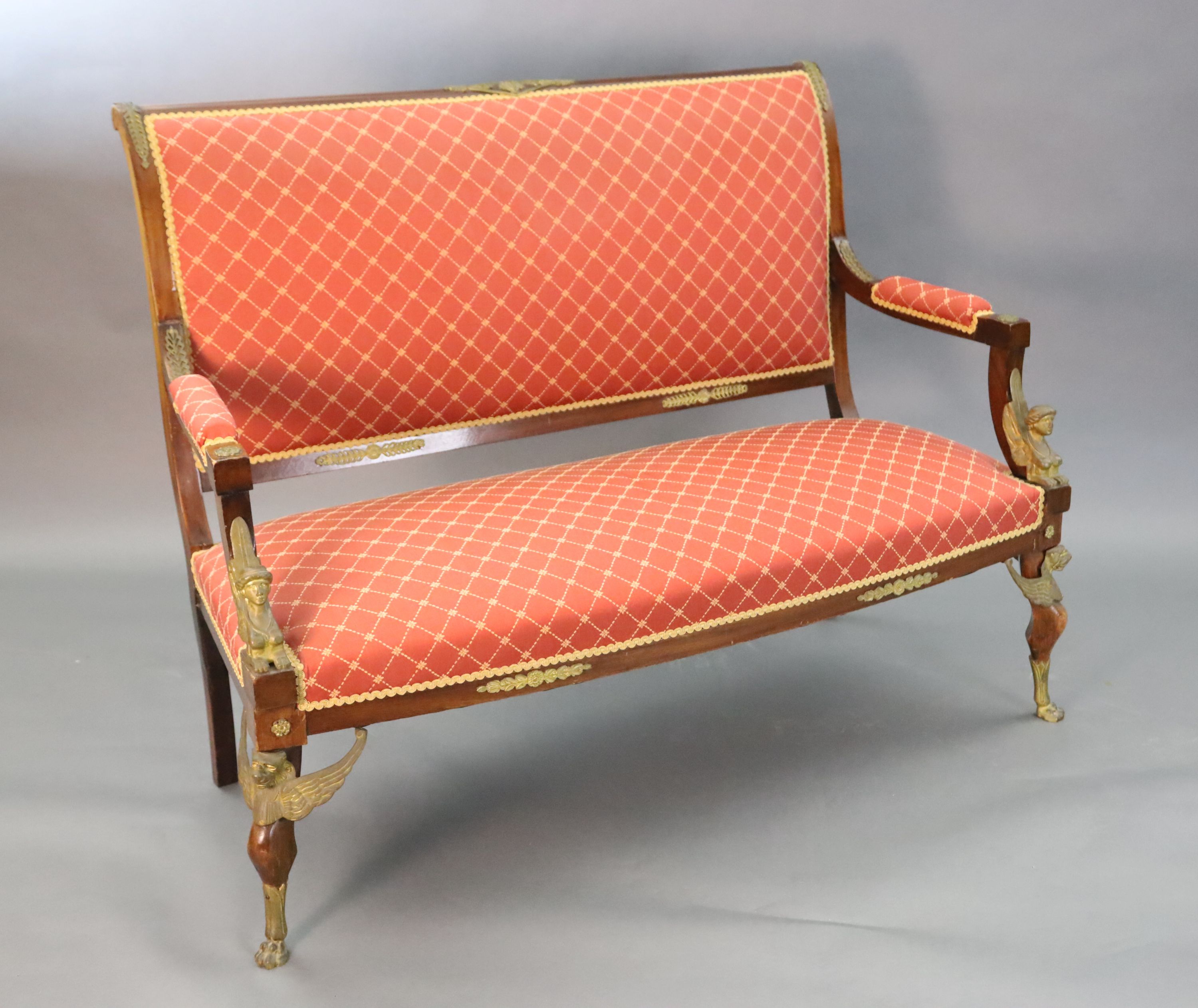 A late 19th century French Empire style ormolu mounted mahogany three piece salon suite, settee W.4ft 7in. D.2ft 5in. H.3ft 6in.
